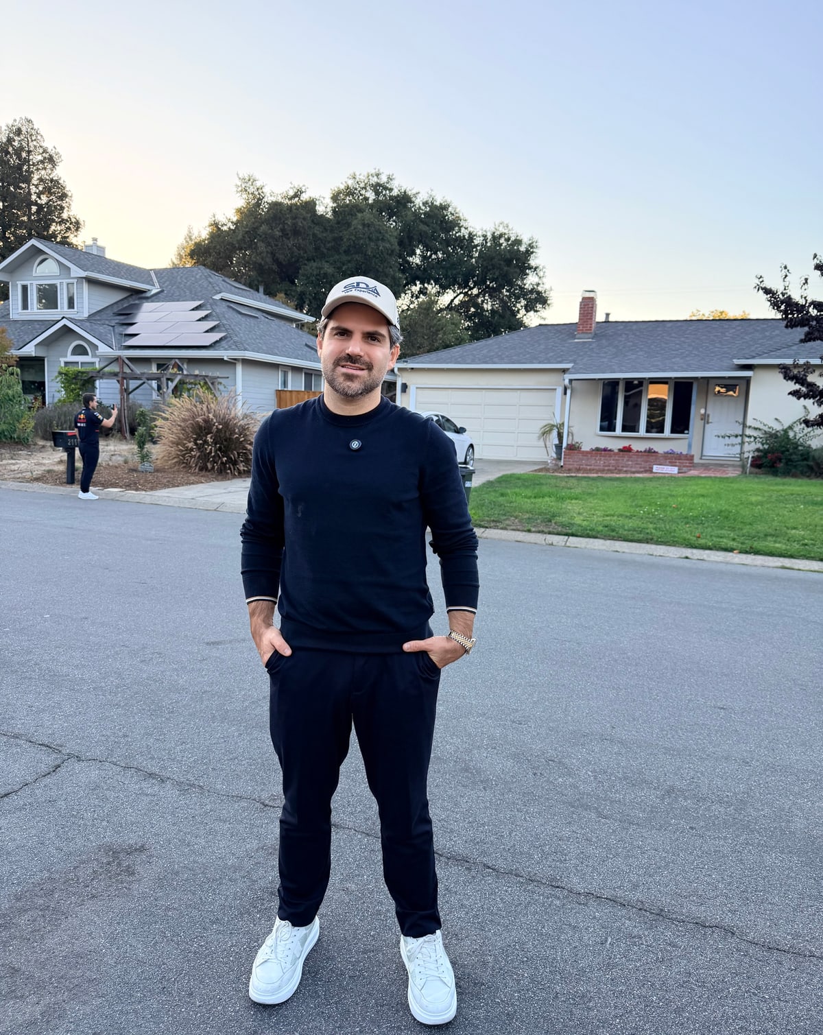 Samuel Pereira na rua em frente à casa de Los Altos onde a Apple começou, com a garagem visível ao fundo no fim da tarde