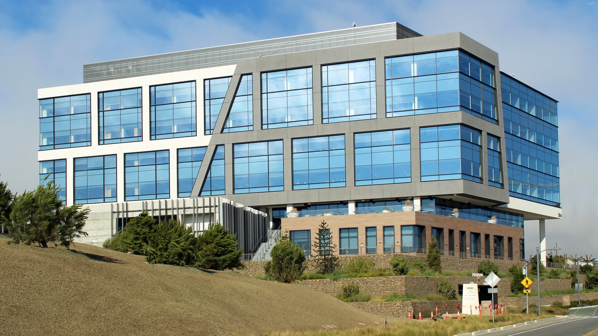 Sede da Stripe em South San Francisco, prédio de vidro azul e concreto visto de fora em dia de céu limpo