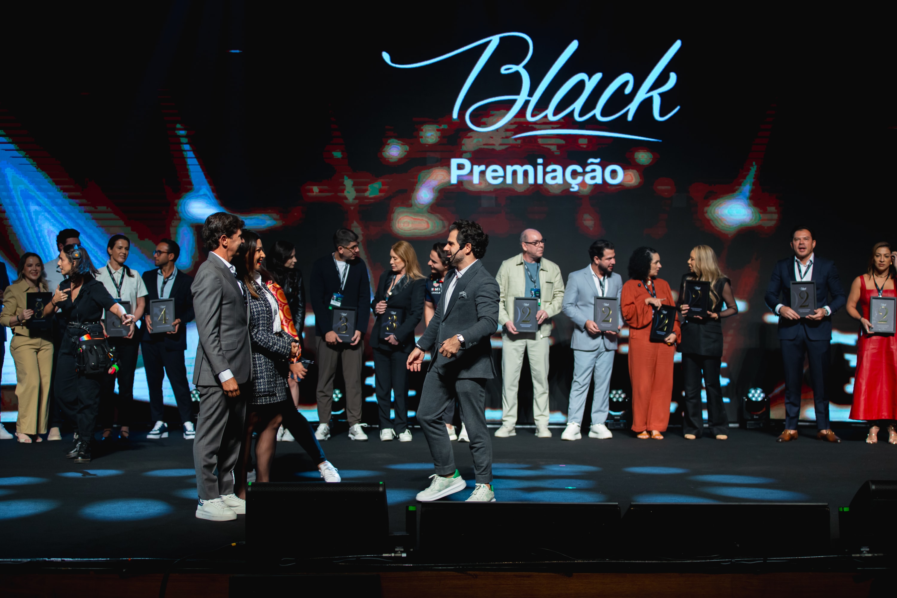Premiação no palco do evento Black da SDA Holding, com empresários recebendo placas