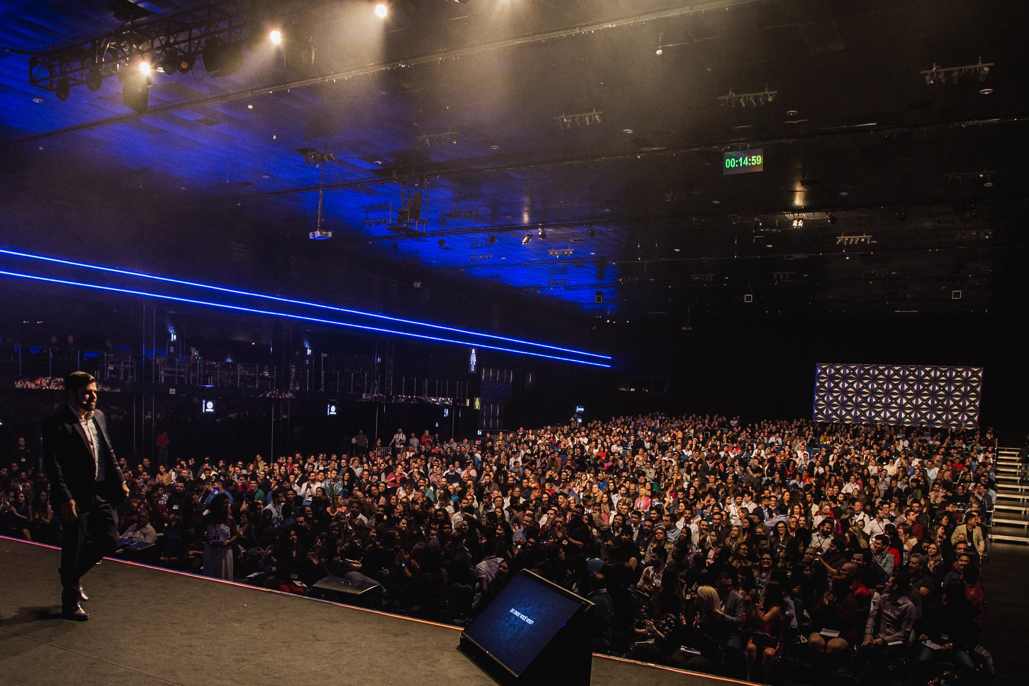 Samuel Pereira no palco olhando para a arena lotada durante um evento do Segredos da Audiência